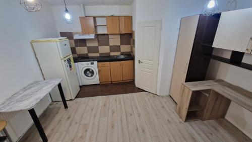 eine kleine Küche mit einem Kühlschrank, einer Waschmaschine und einem Trockner in der Unterkunft Stejarului App25 in Floreşti