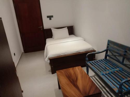 KaragampitiyaにあるCoza Ceylonの小さなベッドルーム(ベッド1台、ベンチ付)