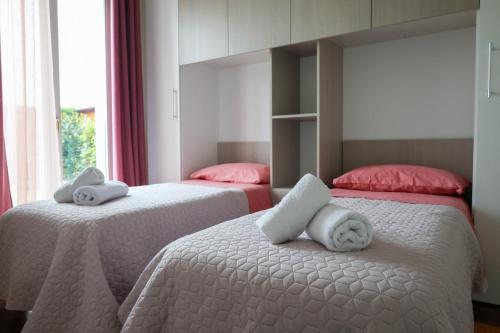 2 Betten mit Handtüchern in einem Schlafzimmer in der Unterkunft Casa di Lulù (lago e Spiaggia) in Manerba del Garda