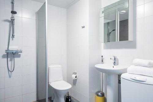ein weißes Bad mit einem WC und einem Waschbecken in der Unterkunft Center located apartment close to University in Tampere