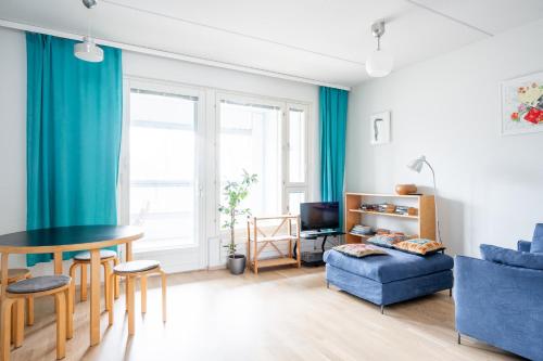 ein Wohnzimmer mit einem Tisch und einem blauen Sofa in der Unterkunft Center located apartment close to University in Tampere