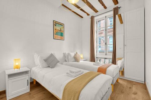 deux lits dans une chambre blanche avec une fenêtre dans l'établissement Mess d'Yvonne - 45m2 en plein cœur de Toulouse, à Toulouse