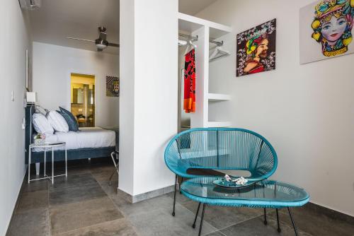 a room with a blue chair and a bed at Dream View Suites Taormina in Taormina