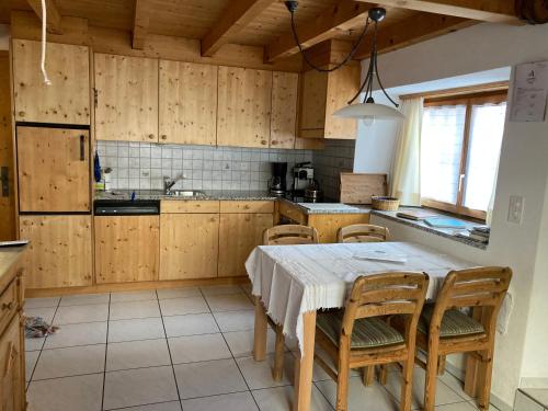 a kitchen with wooden cabinets and a table and chairs at Fravgia veglia in Andeer