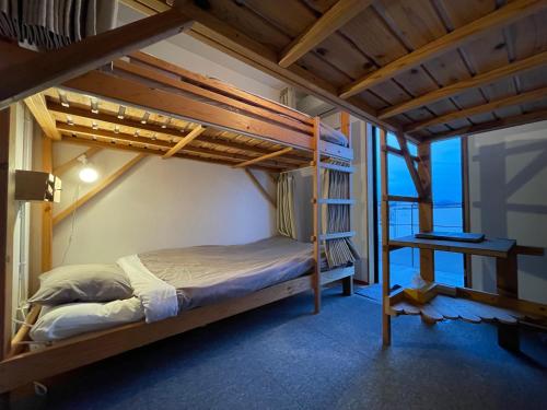 een slaapkamer met een stapelbed en een ladder bij guest house Active Life -YADO- in Ishinomaki