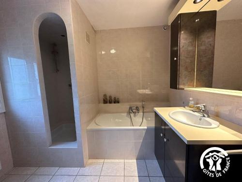 een badkamer met een bad, een wastafel en een bad bij La Villa Blanche - 2 personnes in Saint-Jean-de-Fos