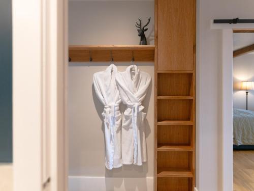 a white robe hanging on a shelf in a bedroom at Askival Studio - Ukc6563 in Mallaig