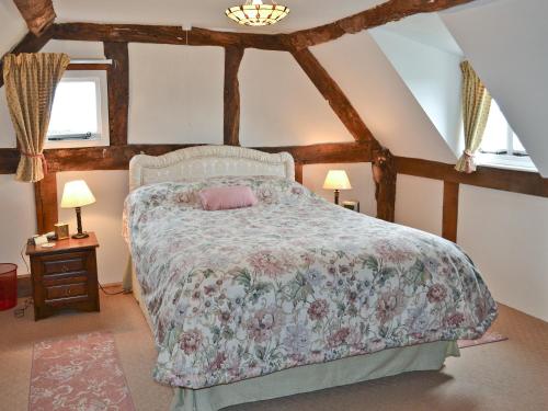 um quarto com uma cama com colcha floral em Bank Cottage em Boraston