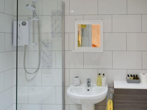 a white bathroom with a sink and a shower at Limewood Lodge in Kingthorpe