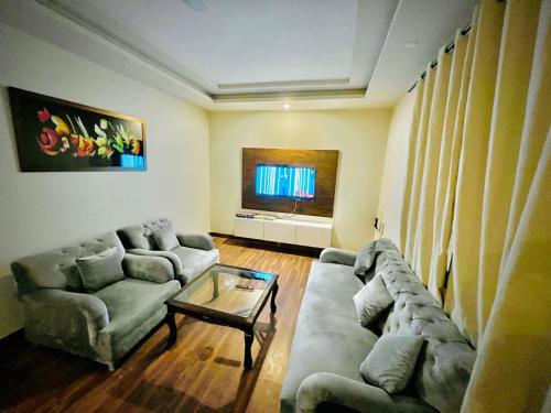 ein Wohnzimmer mit einem Sofa und einem Tisch in der Unterkunft Luxe and Family-friendly 2BHK in Islamabad