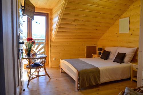 a bedroom with a bed and a table in a room at Highland Retreat Dzianisz in Witów