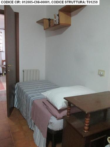 uma pequena cama num quarto com uma mesa em Pit Stop Jerago em Cavaria