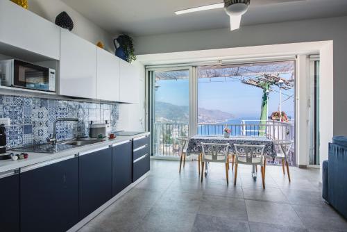 a kitchen with a table and a view of the ocean at Dream View Suites Taormina in Taormina