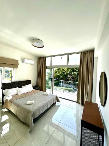 een slaapkamer met een bed en een groot raam bij Seaside Bliss 1-Bed Apt in Paphos City