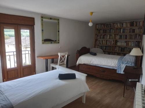 a bedroom with two beds and a desk and book shelves at 643km landa etxea in Villatuerta