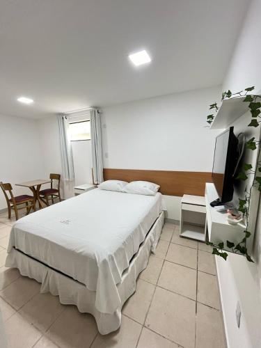 a bedroom with a bed and a flat screen tv at POUSADA PEDRA DE JACÓ in Lauro de Freitas