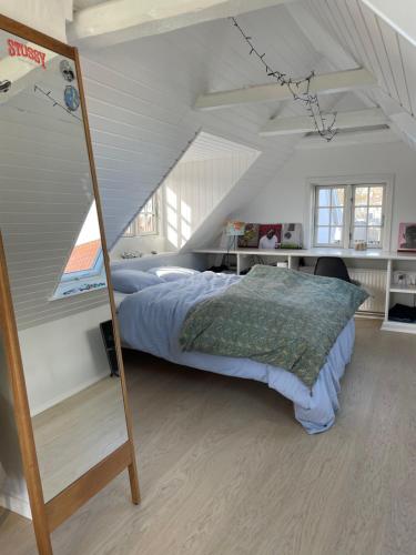 una camera da letto con un grande letto in mansarda di Harbour House a Hornbæk