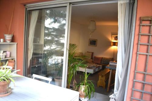 un salon avec une porte coulissante en verre ornée de plantes dans l'établissement Appartement super clair, à Nice
