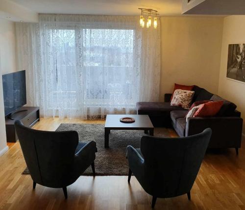 a living room with a couch and chairs and a table at Rubita Apartments in Pärnu