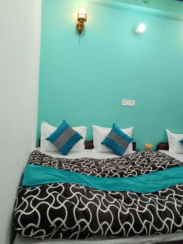 a bedroom with a large bed with blue walls at Hotel Tejas in Gupta Kāshi