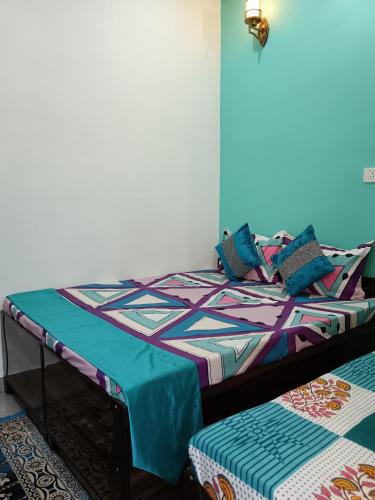 a bedroom with a bed with a colorful comforter at Hotel Tejas in Gupta Kāshi