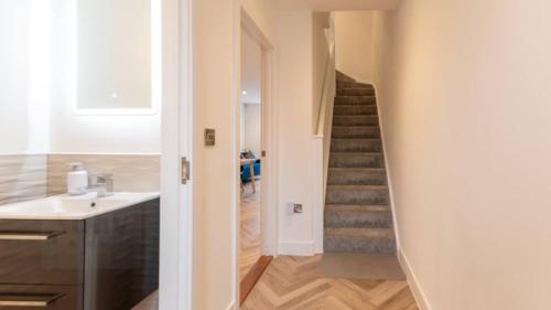 a bathroom with a sink and a staircase at Stylish Westgate-on-sea Haven Near Beach in Margate