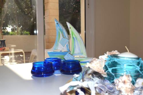 a group of blue glass boats sitting on a table at Villa Calm 100m from the beach in Ayia Napa