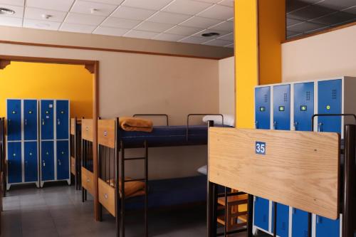 a row of bunk beds in a room with lockers at ALBERGUE DON QUIJOTE in Arzúa
