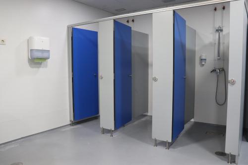 a row of blue stalls in a hospital room at ALBERGUE DON QUIJOTE in Arzúa