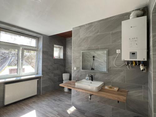 baño con lavabo y ventana en Wilson Paradise Guest House, en Thenneberg