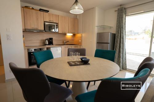 une cuisine et une salle à manger avec une table et des chaises dans l'établissement Grand T3 neuf climatisé avec WIFI à 100m de la plage, à Vias