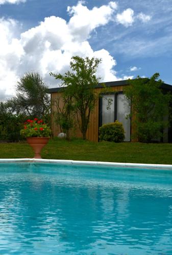 a swimming pool with a house in the background at Palazzo delle Biscie - Old Tower & Village in Molinella