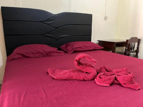 a pink snake laying on top of a bed at EL Homestay Bunaken in Bunaken