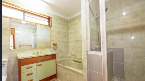 La salle de bains est pourvue d'une baignoire, d'un lavabo et d'une douche. dans l'établissement Greenhill Rockhampton, à Rockhampton