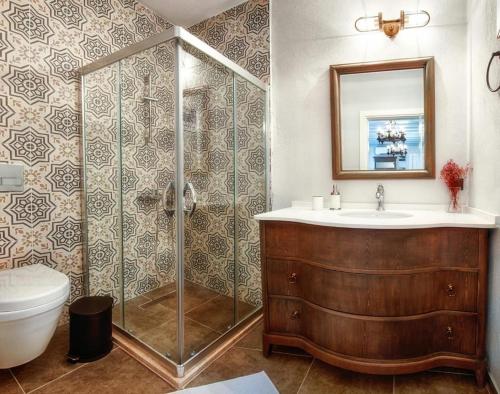 a bathroom with a shower and a sink and a toilet at Petite Boutique Hotel in Ildır