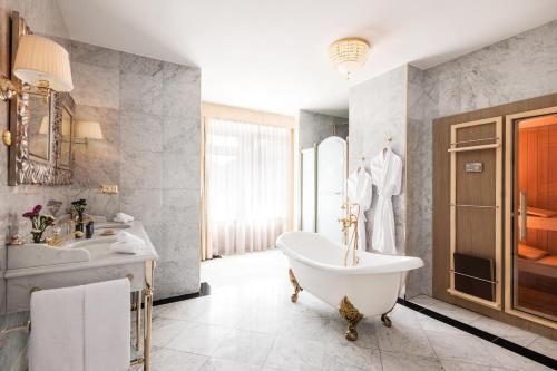 ein Badezimmer mit einer Badewanne und einem Waschbecken in der Unterkunft Hotel Flüela Davos - The Unbound Collection by Hyatt in Davos