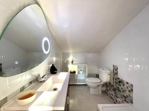 a bathroom with a toilet and a sink and a mirror at Alojamiento Turístico Casa Ela in L'Aldea