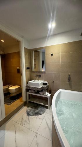 a bathroom with a tub and a sink and a toilet at Cagliari Love Suite in Cagliari
