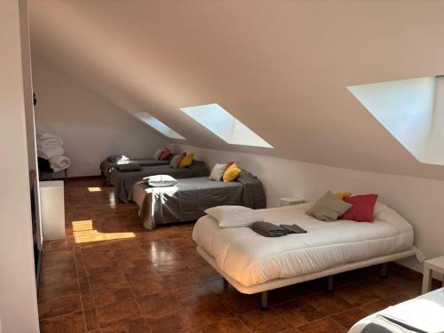 a attic room with three beds and a skylight at Villa Tamarindo 8 in Córdoba