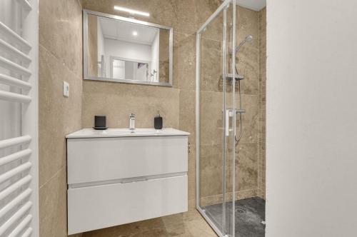 une salle de bain avec un lavabo blanc et une douche dans l'établissement Frère Jacques - Appt situé plein centre, à Toulouse