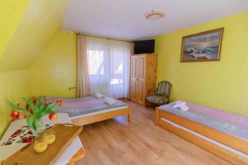 a small room with two beds and a table at Willa Piękne Widoki in Ząb