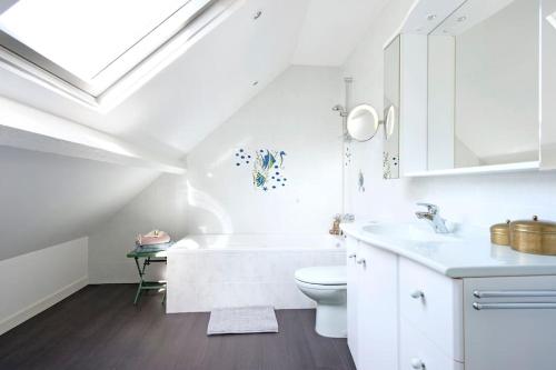 a white bathroom with a toilet and a sink at Loueurdappart - Grande Maison Zen et Très bien équipée 5 Min plage in La Baule