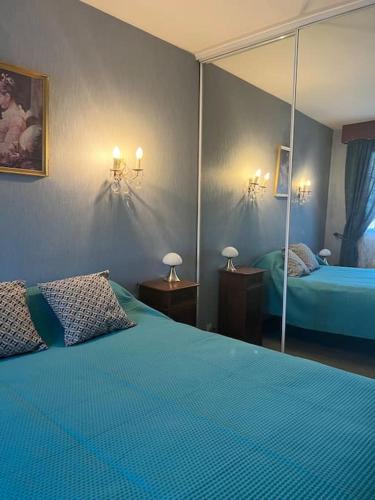 une chambre avec un lit bleu et un miroir dans l'établissement Maison familiale idéalement située avec tout le confort, à Nîmes