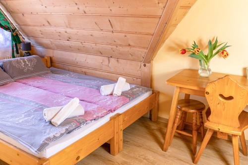 a bedroom with a bed and a wooden table at Willa Piękne Widoki in Ząb