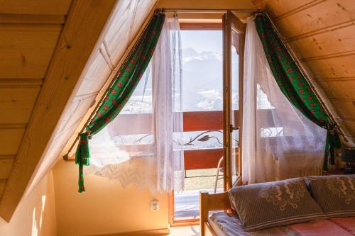 a window in a room with a bed in front of it at Willa Piękne Widoki in Ząb