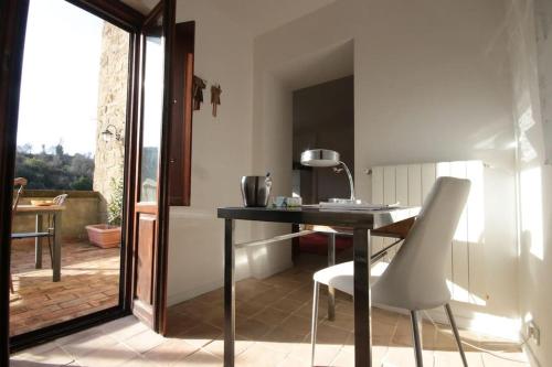 einen Tisch und Stühle in einem Zimmer mit Balkon in der Unterkunft la casetta nel borgo in Ischia di Castro