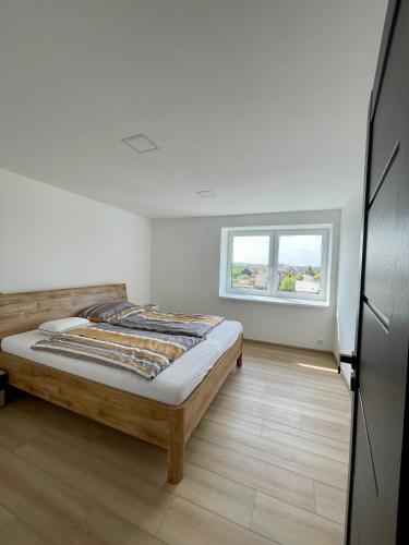 Schlafzimmer mit einem Bett und einem Fenster in der Unterkunft Apartmán v soukromí Hať (u Ostravy) in Hať