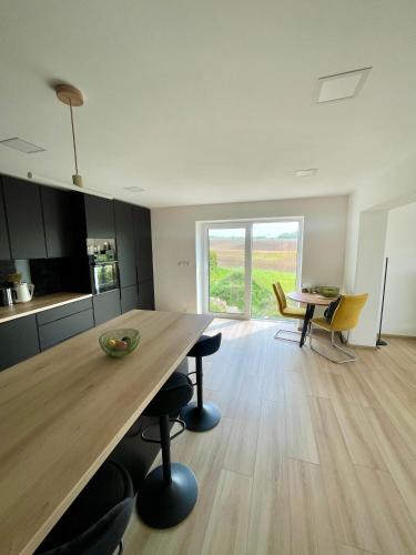 eine Küche und ein Esszimmer mit einem großen Holztisch in der Unterkunft Apartmán v soukromí Hať (u Ostravy) in Hať