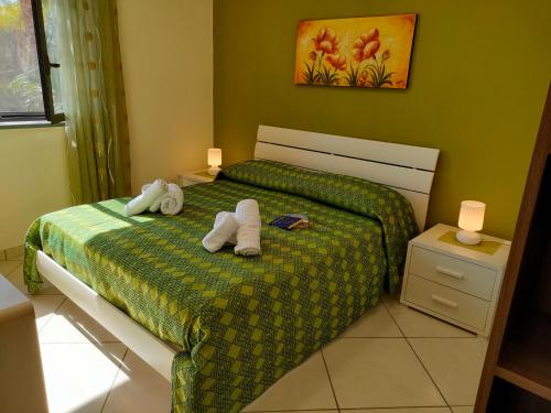 una camera da letto con un letto e asciugamani di Casa dell'Antico Ulivo 1 by Holiday World a Mascali