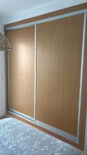 a pair of wooden sliding doors in a bedroom at Acogedor apartamento en la playa con WIFI y AACC in Moncófar